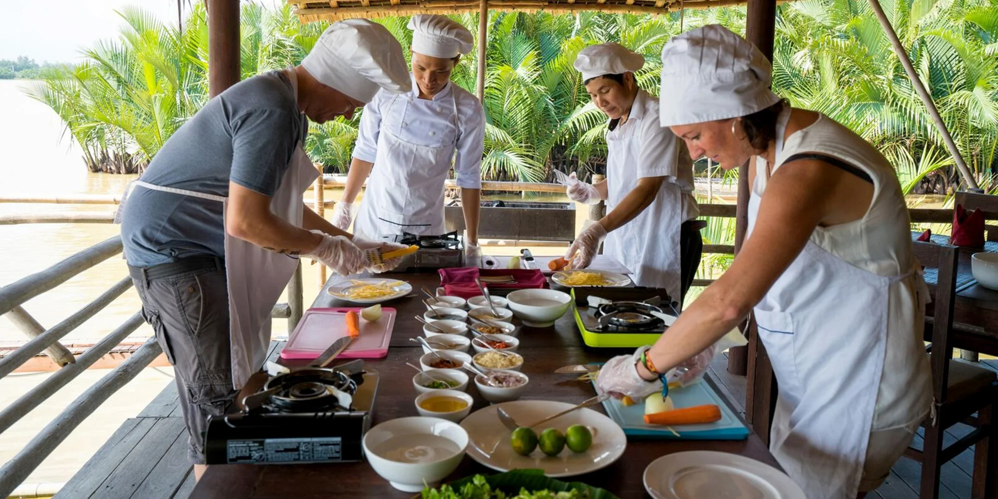 Visitors learn to cook traditional Vietnamese pancakes in a frying pan during a hands-on Cooking Class Hoi An.