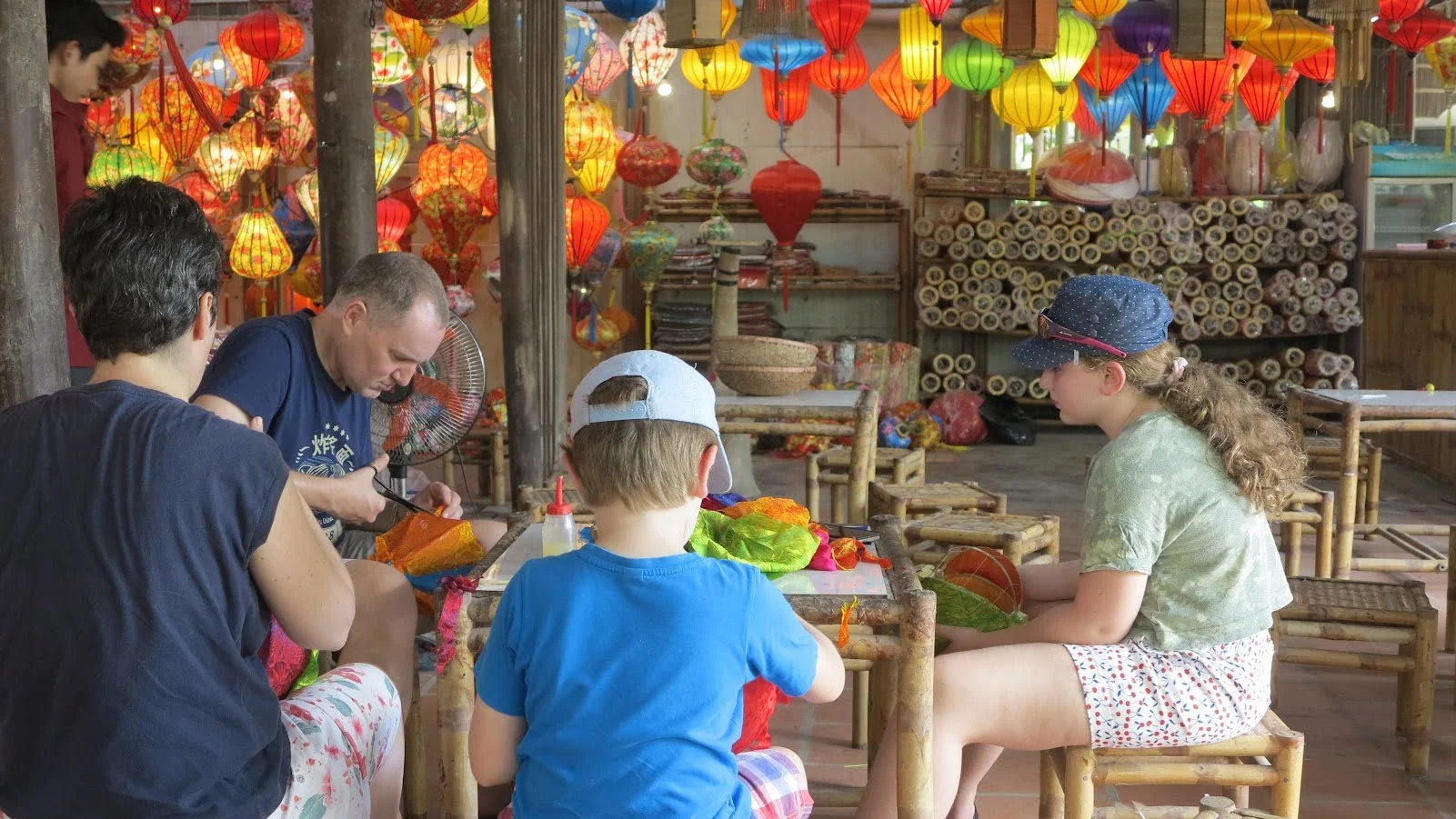 Visitors learning the art of lantern making from a local artisan during our exclusive Hoi An handicraft tour.
