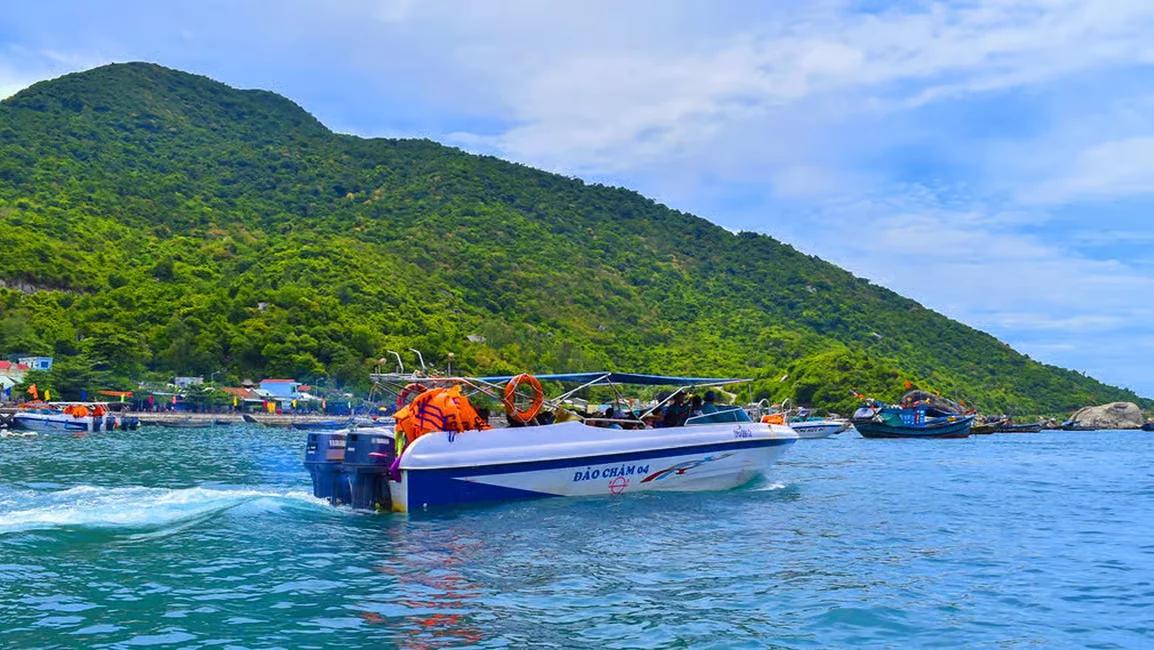 A modern speedboat docking at Bai Lang village during a scenic Cham Island tour from Hoi An.