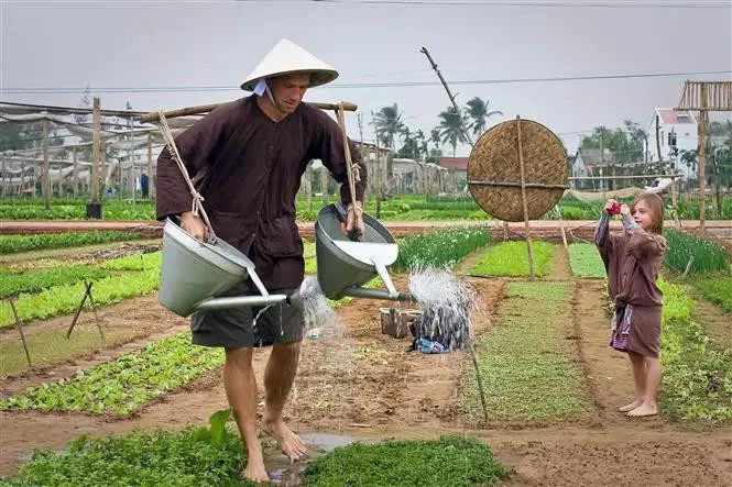 Tourist experiencing eco-farming before joining a hoi an lantern making class