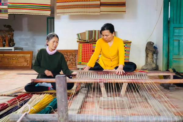 A local woman demonstrating mat weaving during our Hoi An motorbike adventure tours.