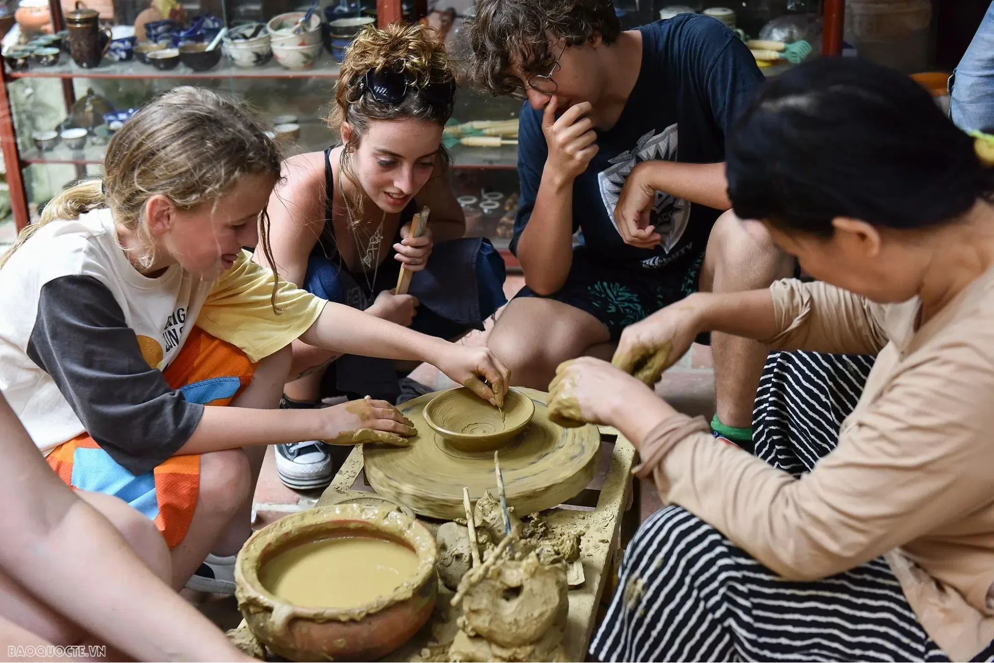 Tourist shaping clay on a potter's wheel at Thanh Ha Village during an authentic Hoi An handicraft tour