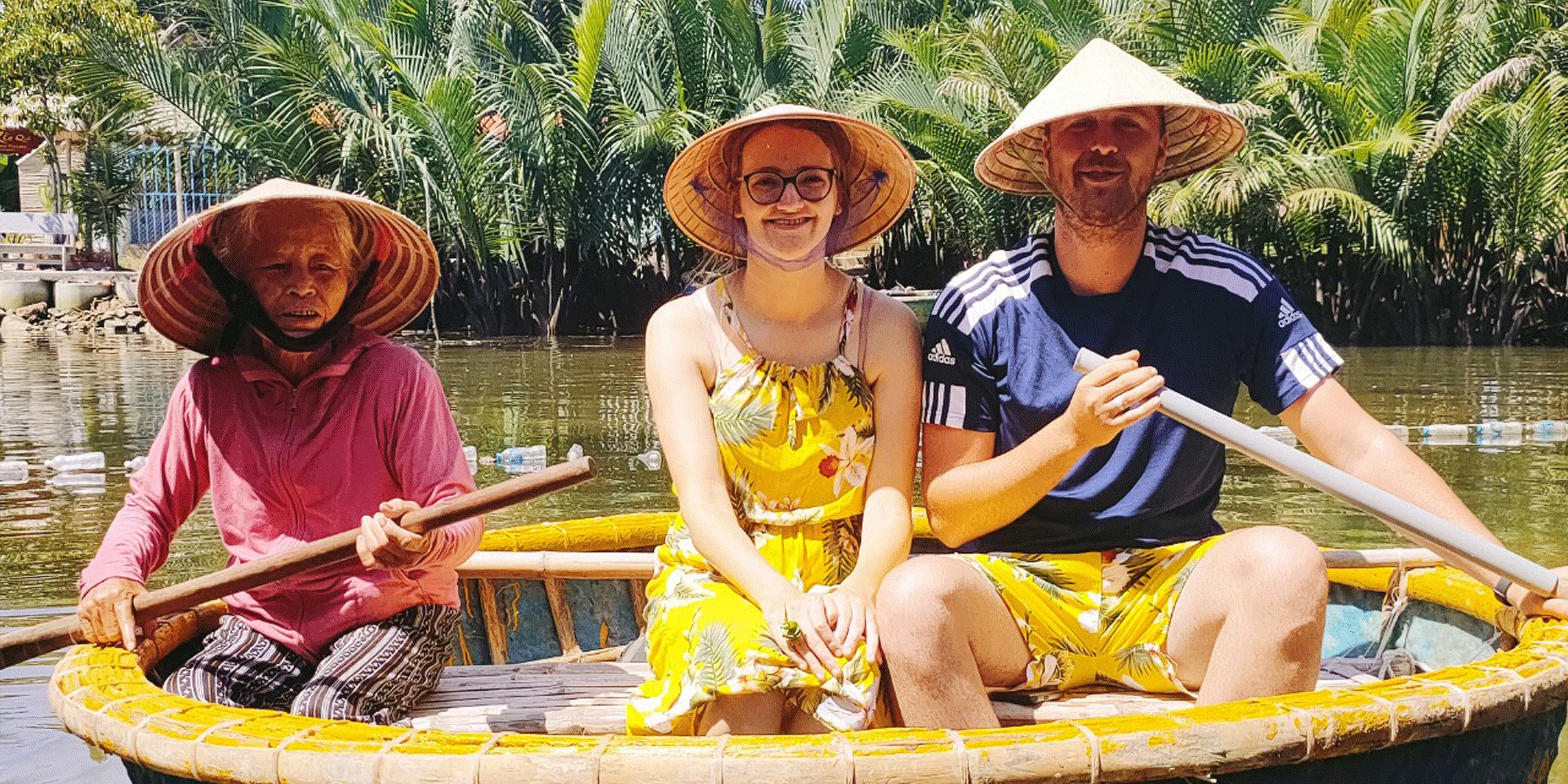 Tourists smiling while riding bamboo basket boats through the green coconut jungle on a Hoi An fishing village tour.