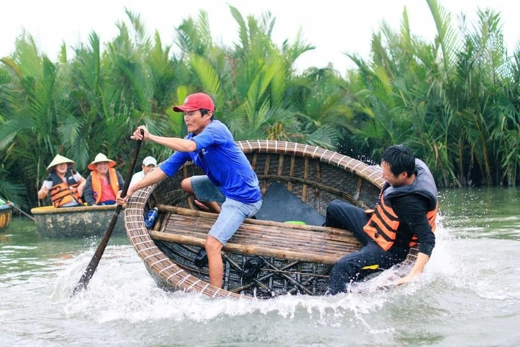Man paddling a basket boat during a Cam Thanh coconut village tour