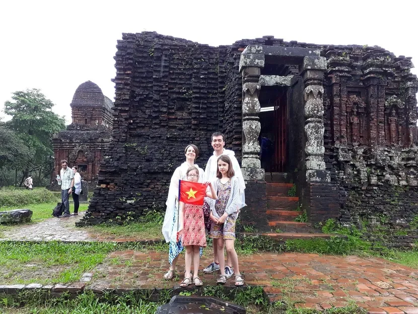 Family exploring ancient red brick towers at My Son Sanctuary