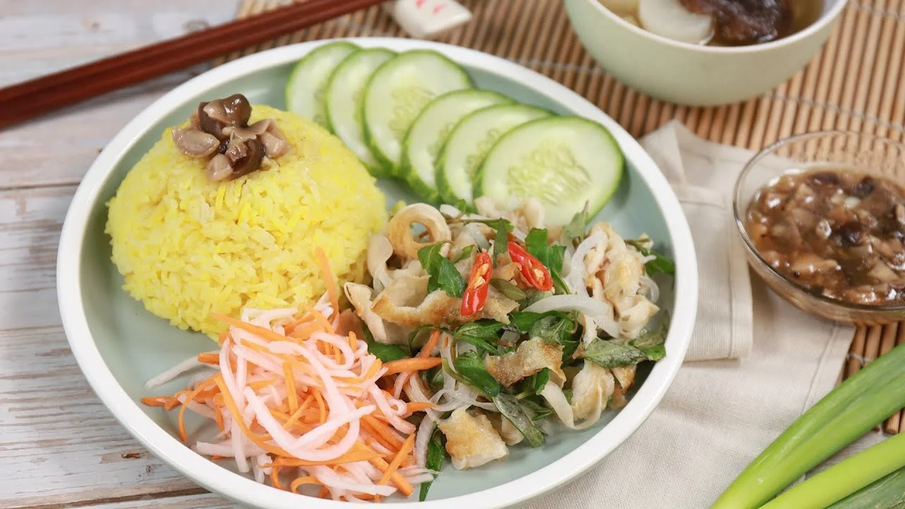 A plate of Hoi An chicken rice with shredded chicken salad and pickled vegetables.