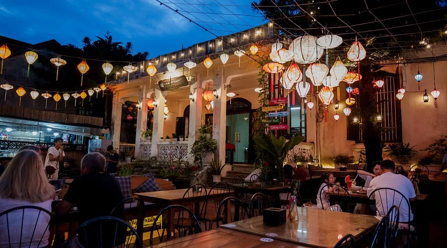Lanterns illuminating the seating area outside a restaurant near Hoi An Market