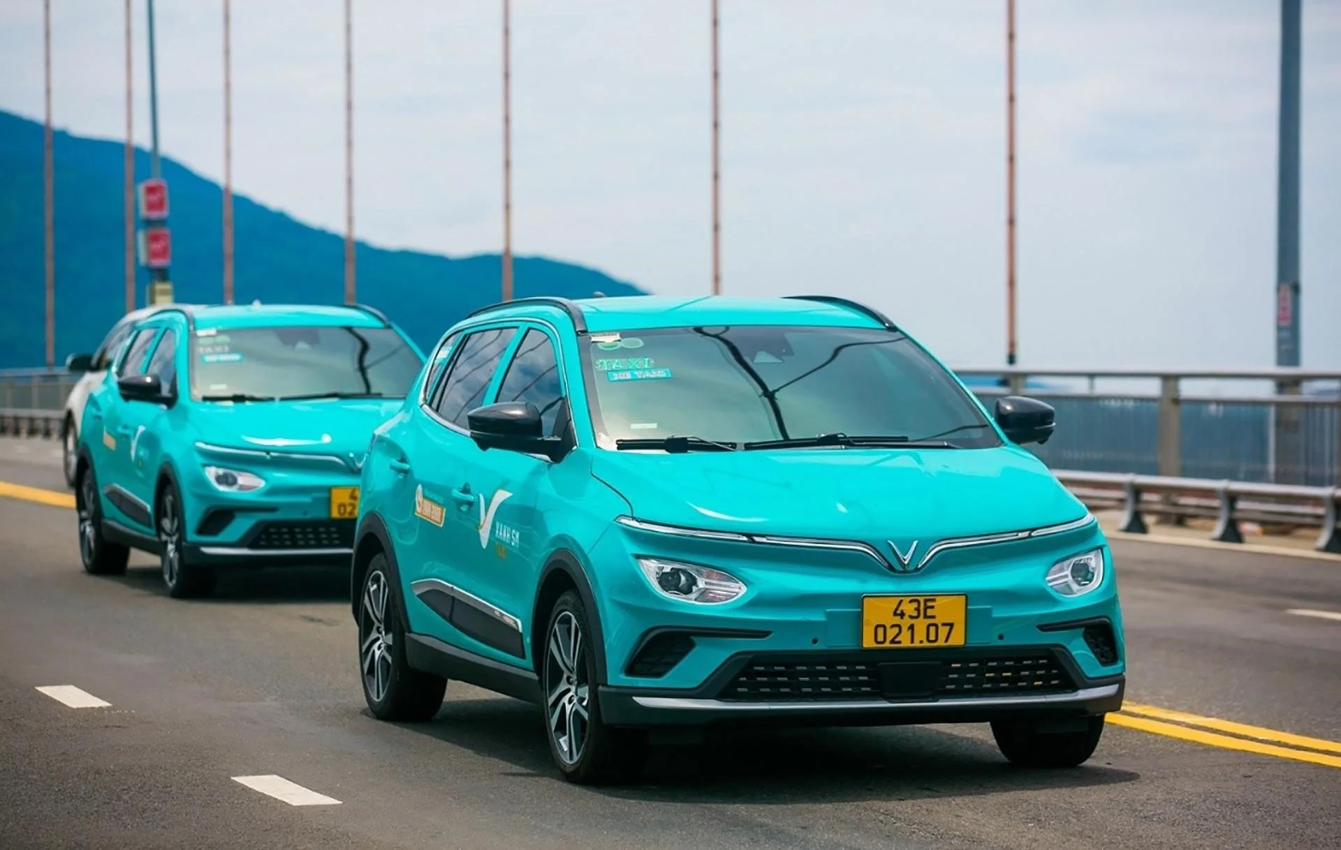 modern electric taxis driving on a bridge, offering a comfortable ride for the journey from An Bang Beach to Hoi An.