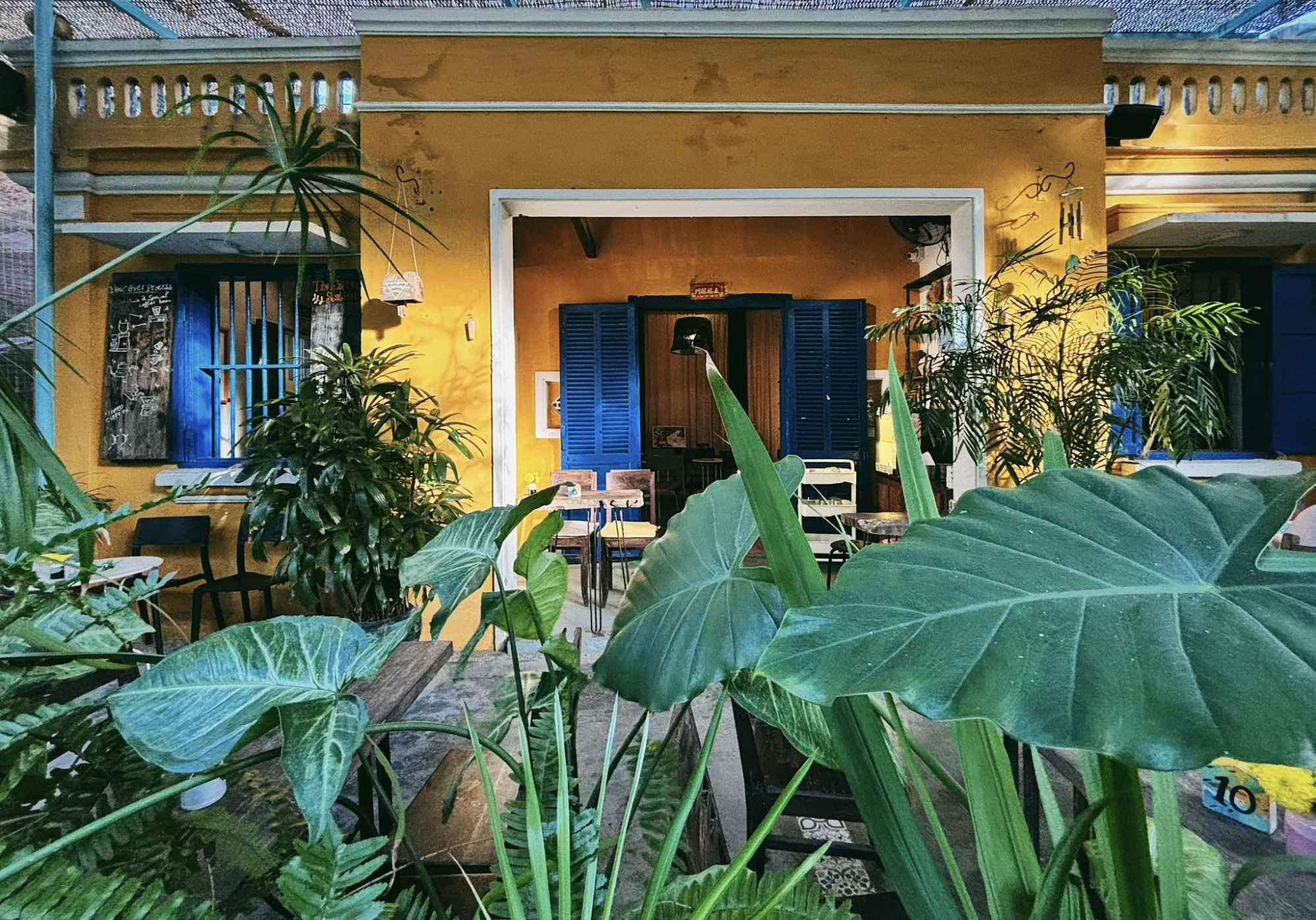 sunlit yellow french colonial architecture at the espresso station serving specialty coffee hoi an