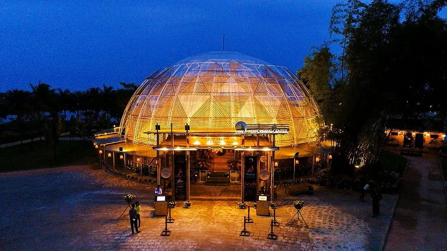 The distinctive, illuminated bamboo dome venue of the Bamboo Circus Hoi An at night.