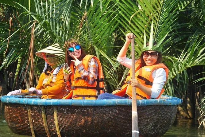 Tourists enjoying a Cam Thanh coconut village basket boat tour