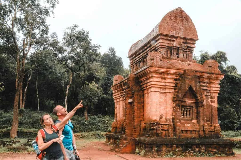Tourists marveling at the ancient red brick architecture of My Son Sanctuary