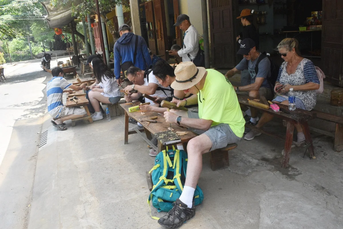 tourists carving wood during a workshop experience at Kim Bong Carpentry Village Hoi An