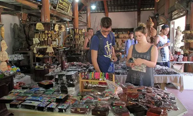 tourists browsing wooden crafts and souvenirs at a shop in Kim Bong Carpentry Village Hoi An