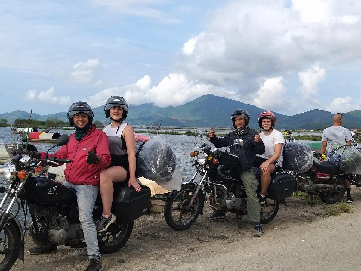 Tourists enjoying a Hue to Hoi An motorbike tour by the water