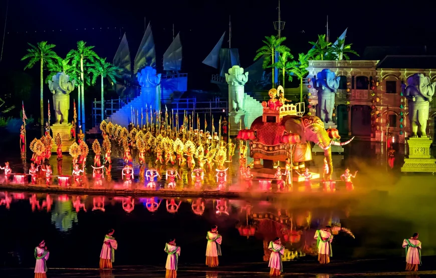 Performers on a grand stage with elephant props and colorful lights, one of the spectacular things to do in Hoi An at night.
