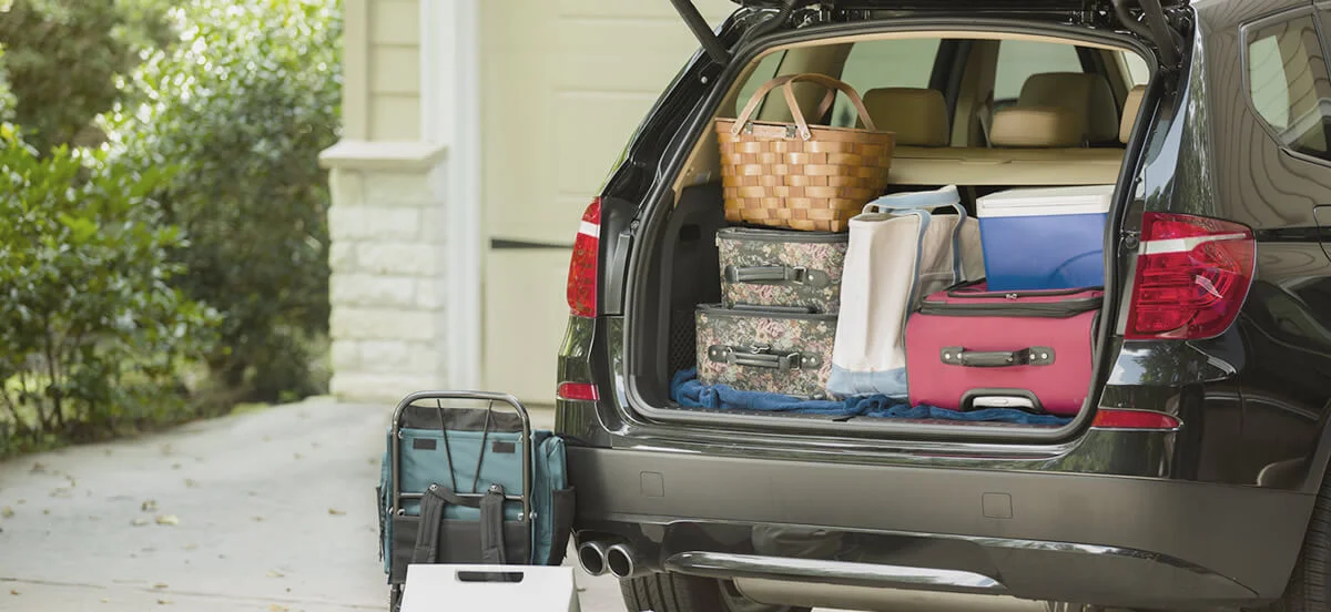 packing luggage into an suv trunk, contemplating the travel choices for your trip to Hoi An vs Hue.