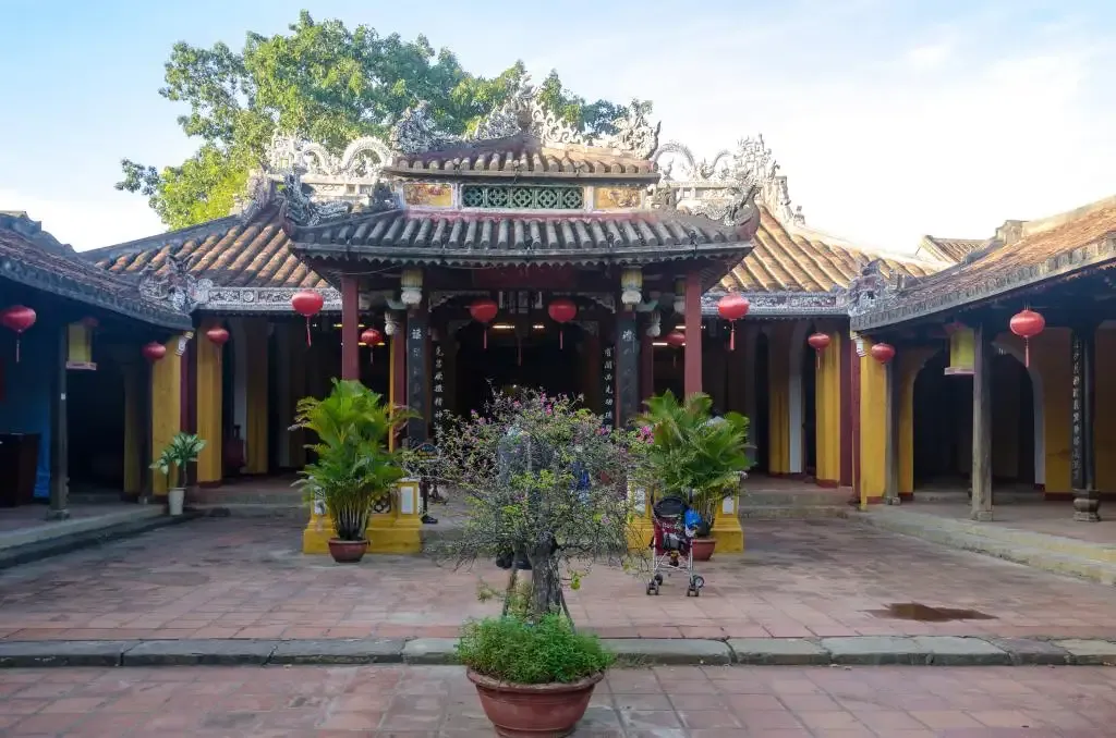 Potted bonsai and red lanterns at the entrance of Cam Pho Communal House.