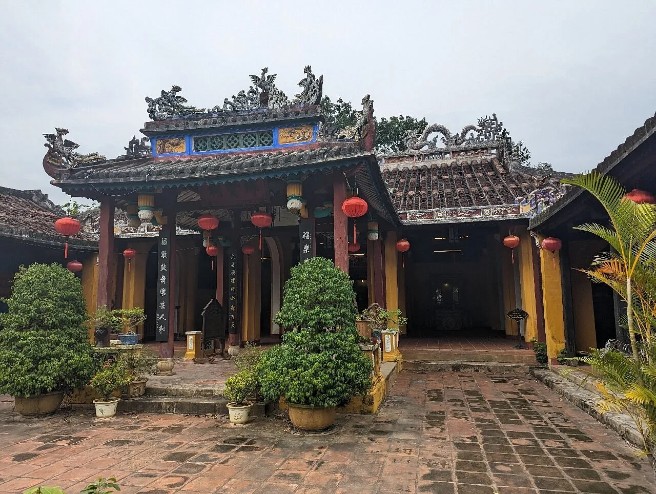 Wooden pillars and tiled roof at the Cam Pho Communal House main hall.