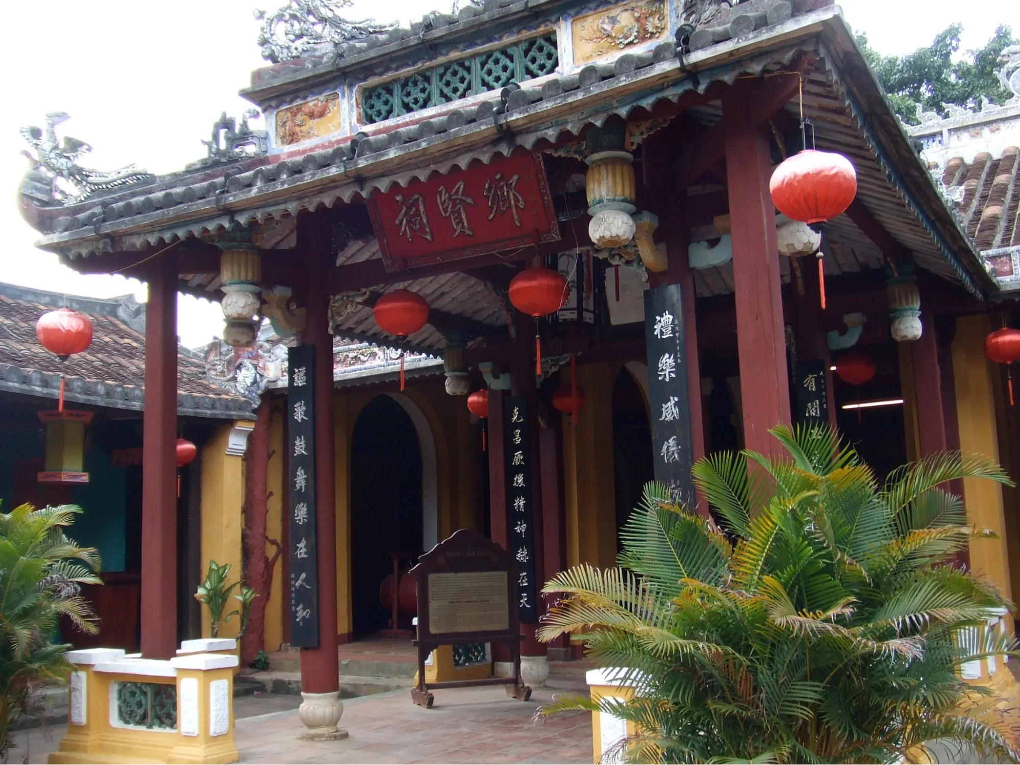 Red lanterns and calligraphy pillars at the entrance of Cam Pho Communal House.