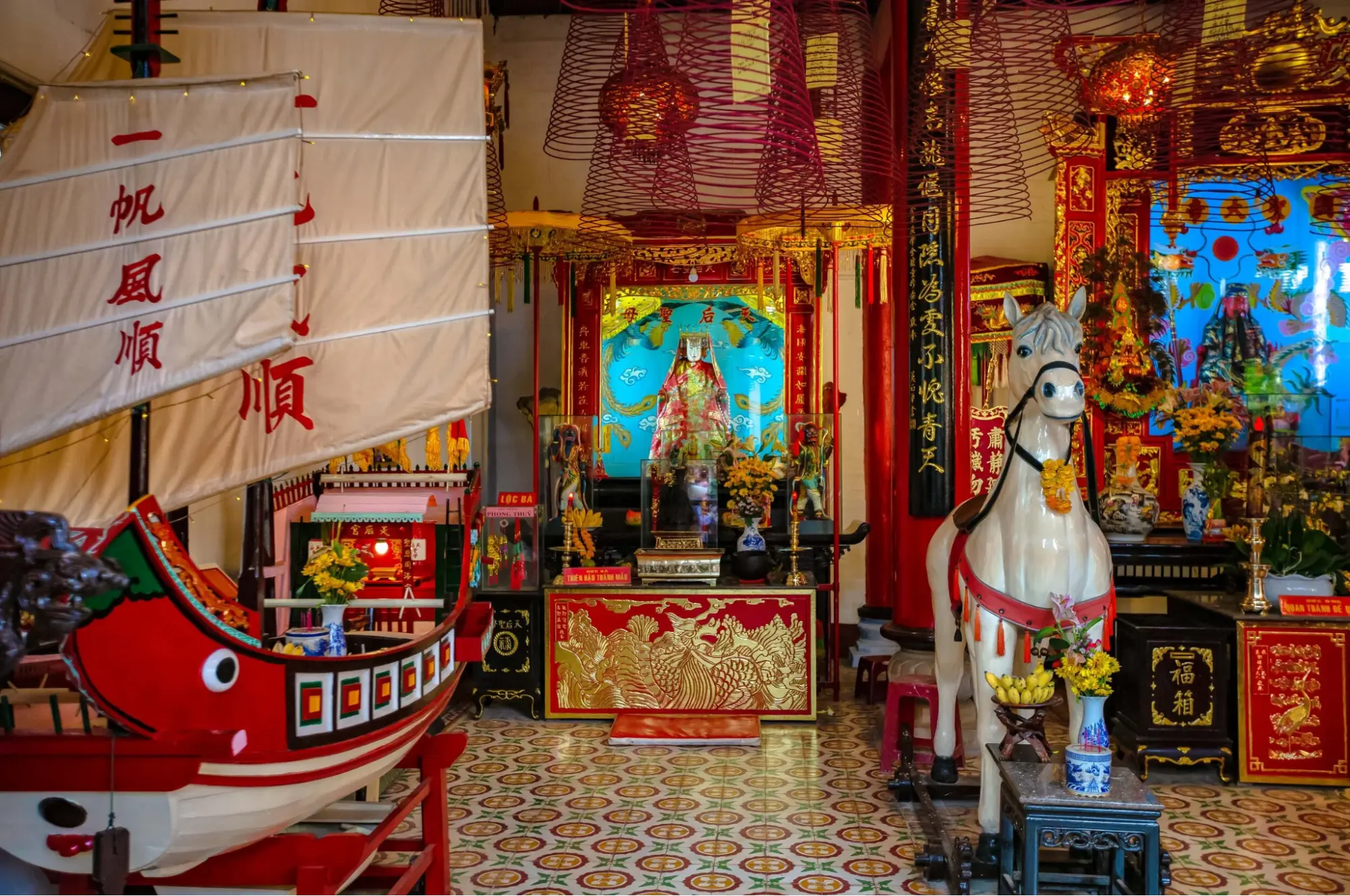 Ornate altar and model ship inside Cantonese Assembly Hall Hoi An
