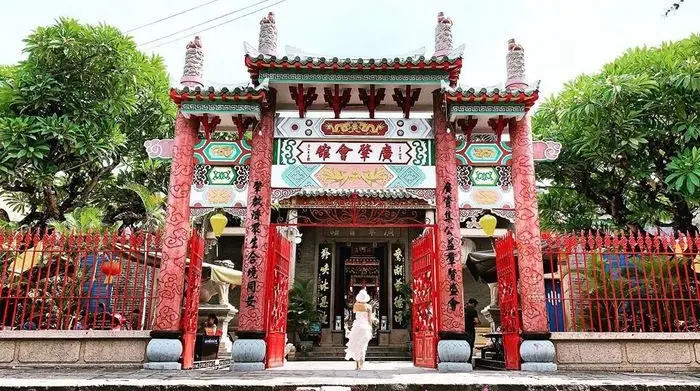 A couple in traditional dress poses before the Cantonese Assembly Hall