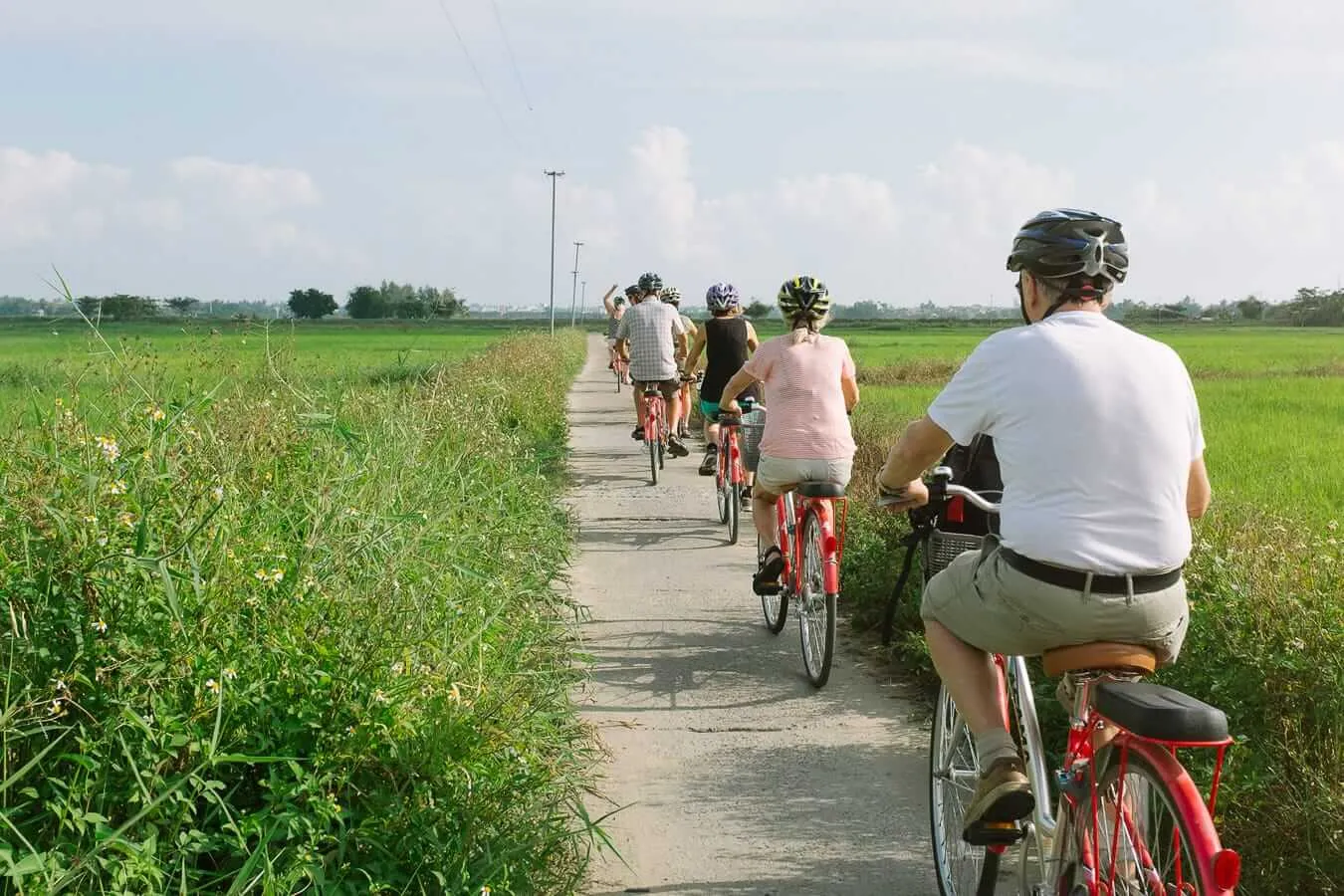 Group on a bicycle rental Hoi An excursion along a narrow village path.