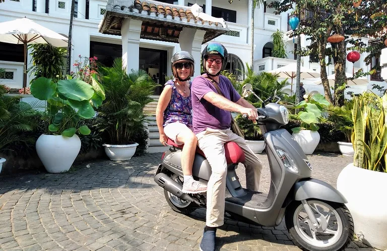 A couple posing on a scooter for their Hoi An bike rental adventure.
