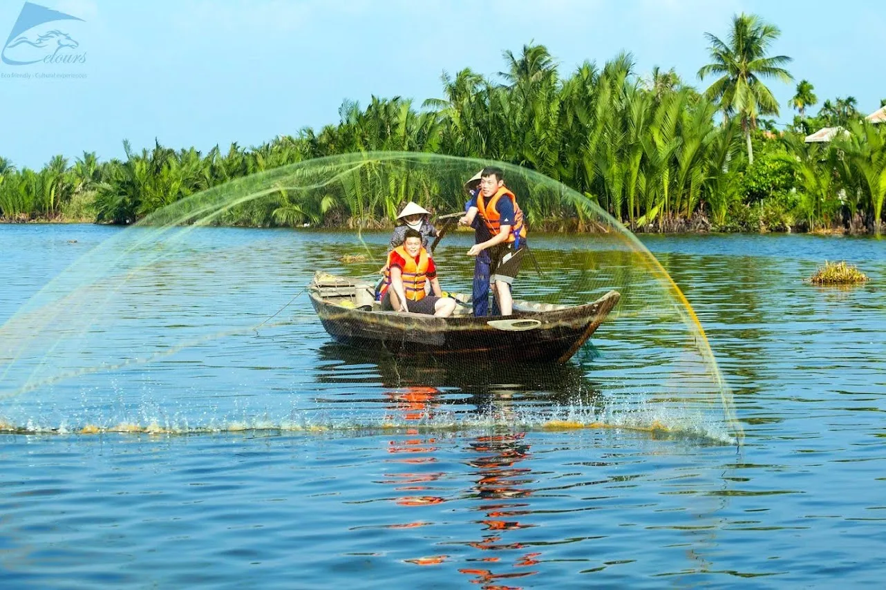 Tourist casting a net from a wooden boat at a Hoi An fishing village.
