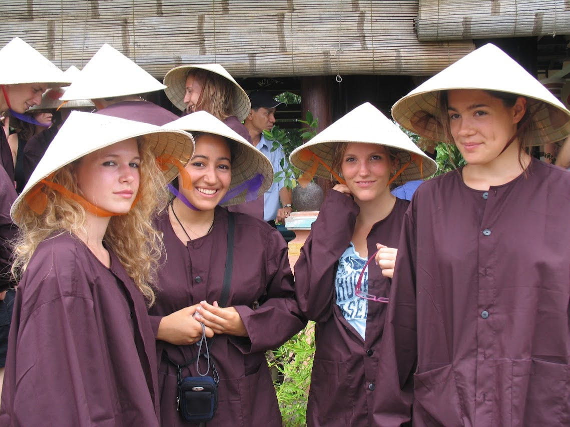 Guests dressed in traditional attire prepare for a lantern-making experience at Tra Que Village in Hoi An.