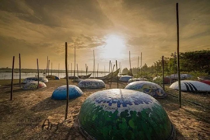 Painted coracle boats resting on the sand at sunset in Tam Thanh Mural Village.
