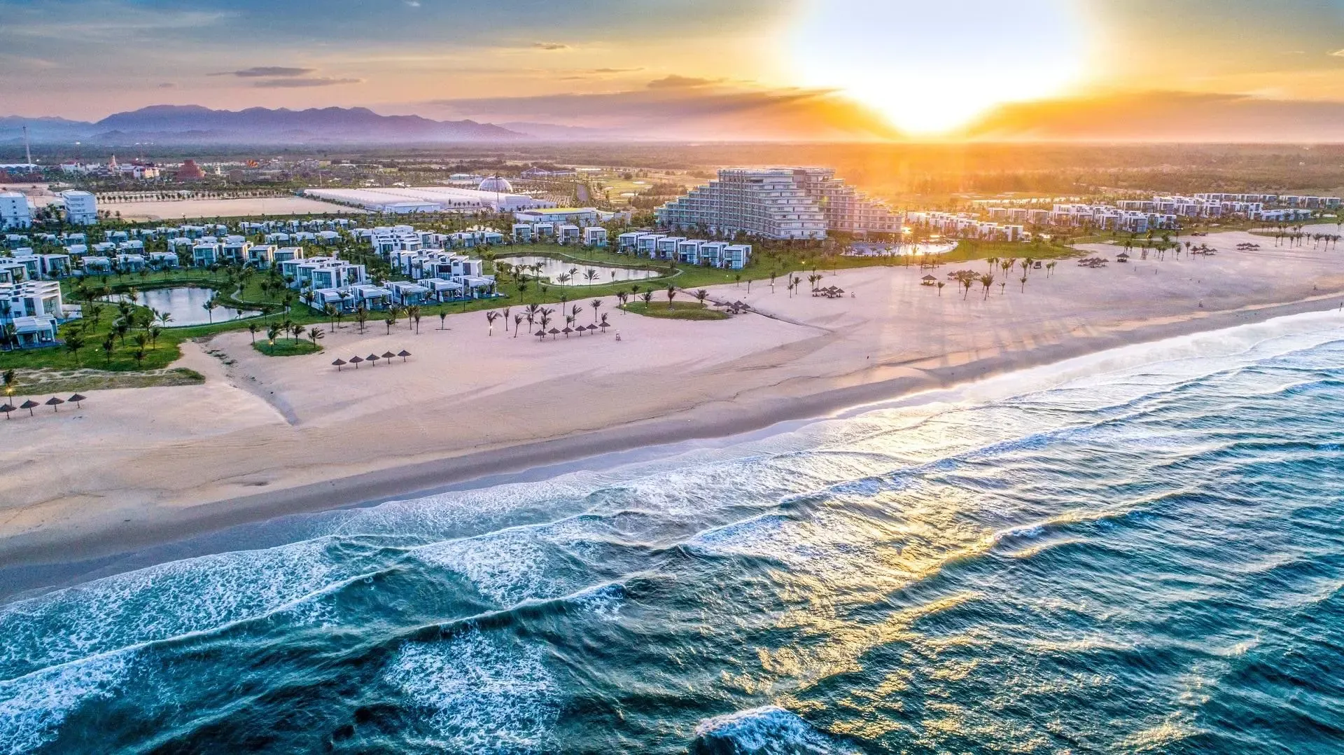 Aerial view of a large coastal resort and beach at sunset near Tam Thanh village.