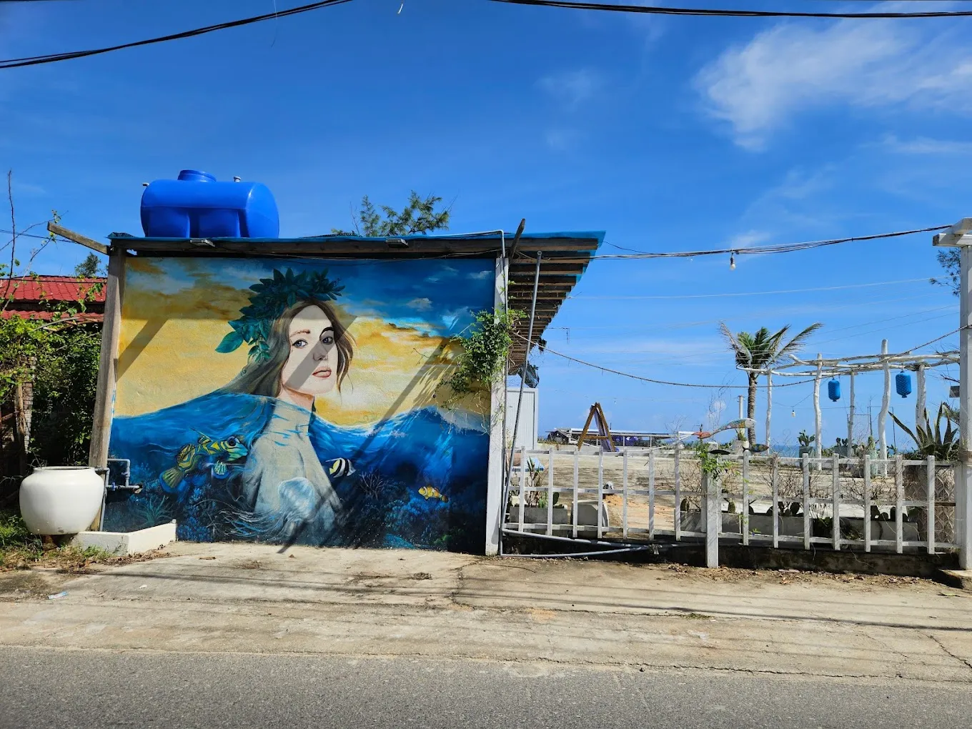 Ocean-themed mural of a woman on a building in Tam Thanh Mural Village.