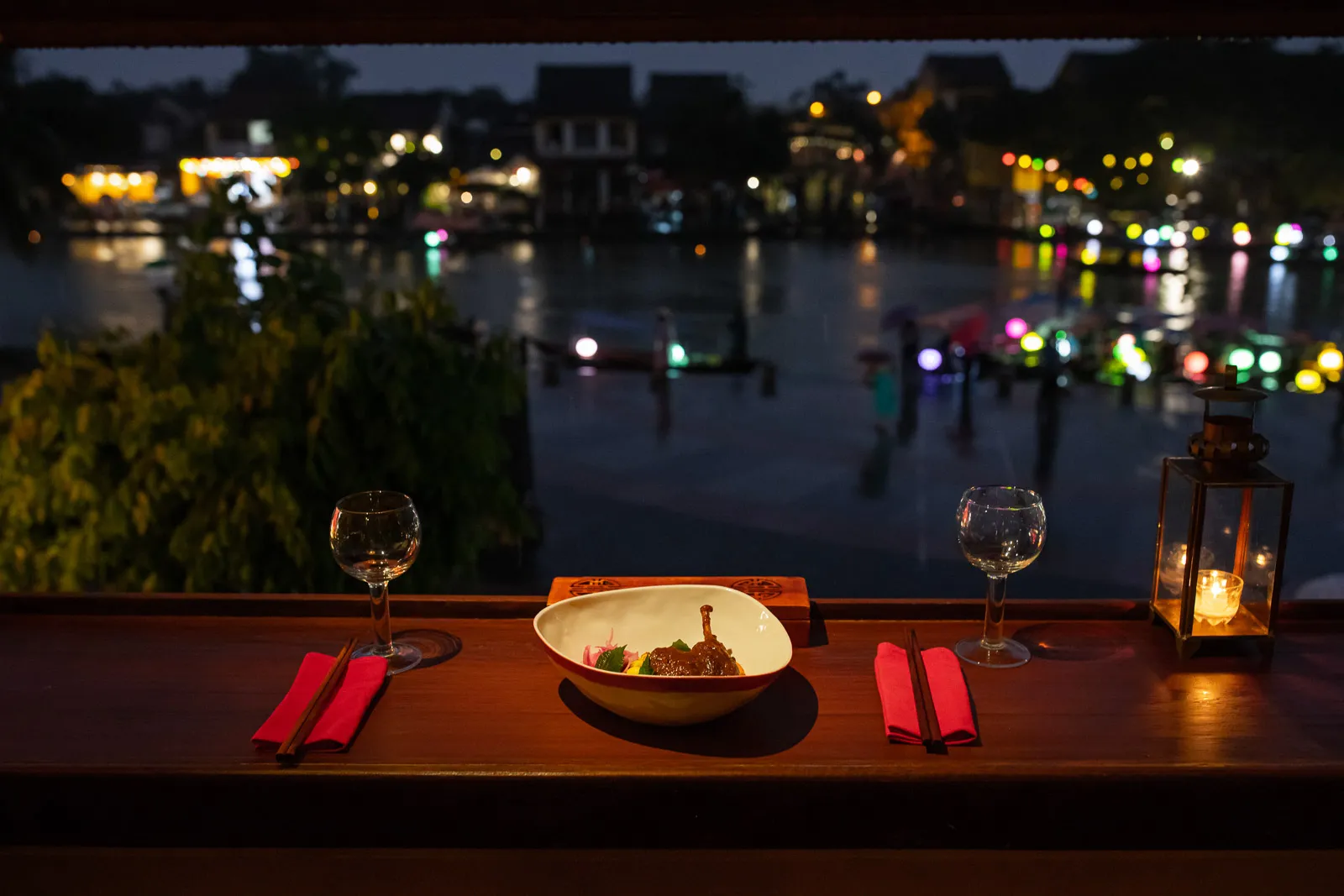 A romantic dinner table overlooking the lights of the Thu Bon River Hoi An.