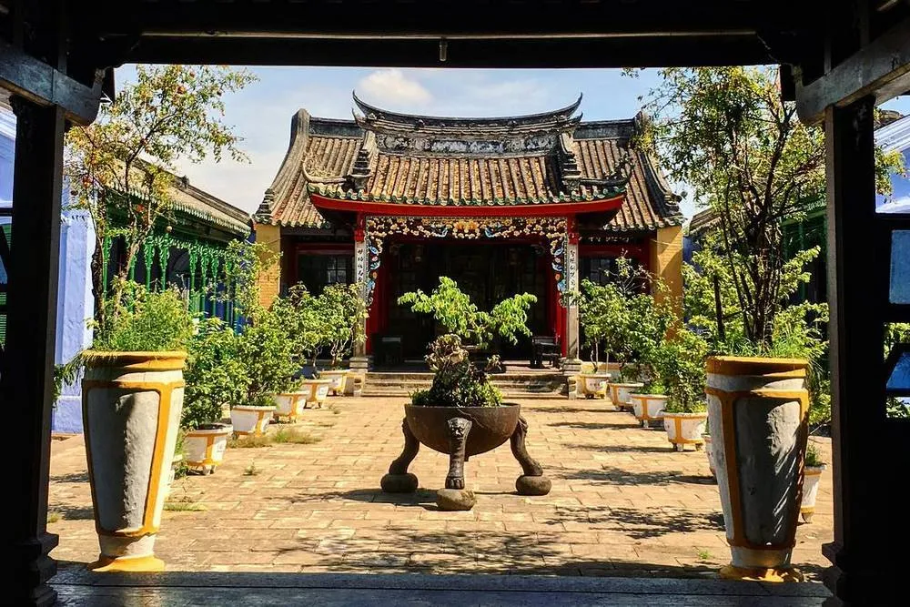 Traditional courtyard with a central bonsai tree leading to the Tran Family Chapel.