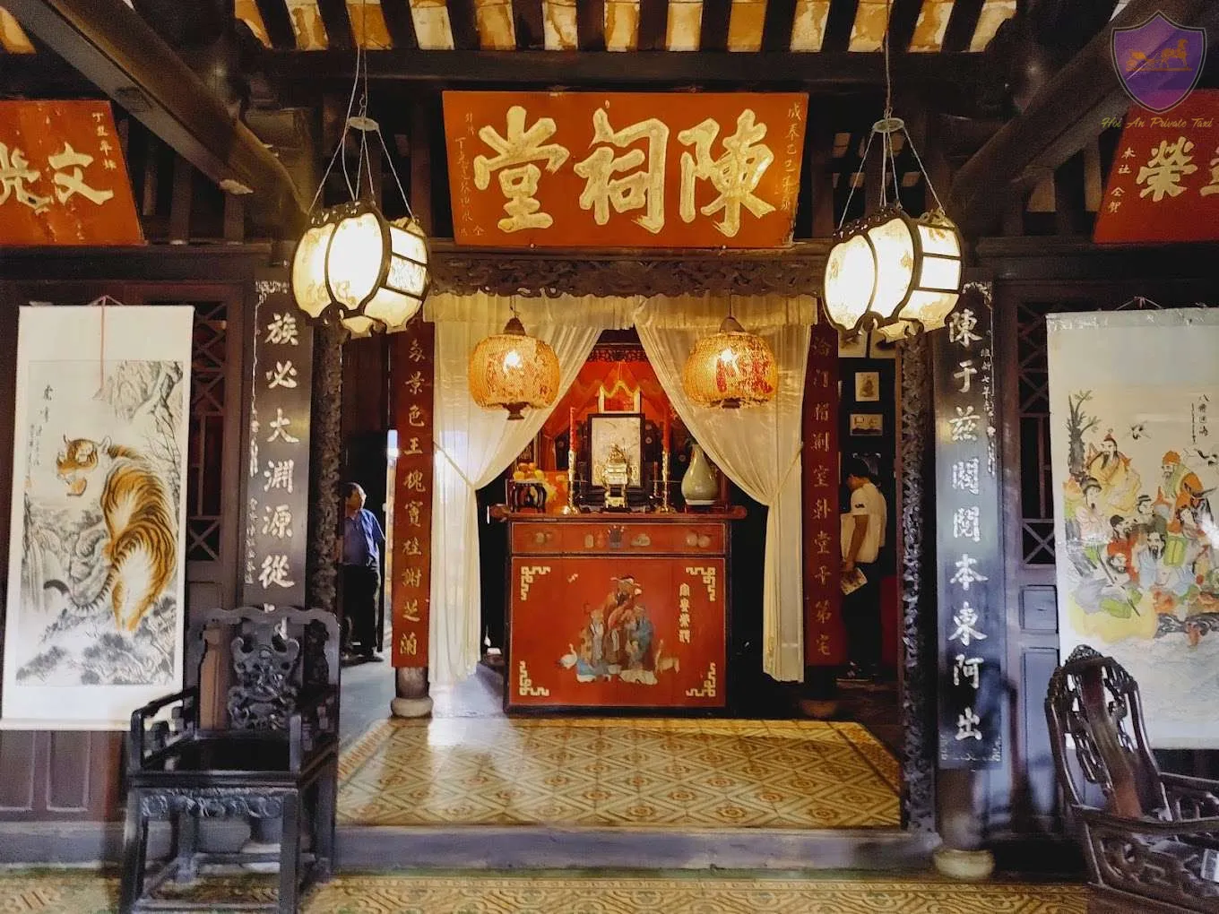 Wooden beams and columns framing a central red ancestral altar of tran family chapel