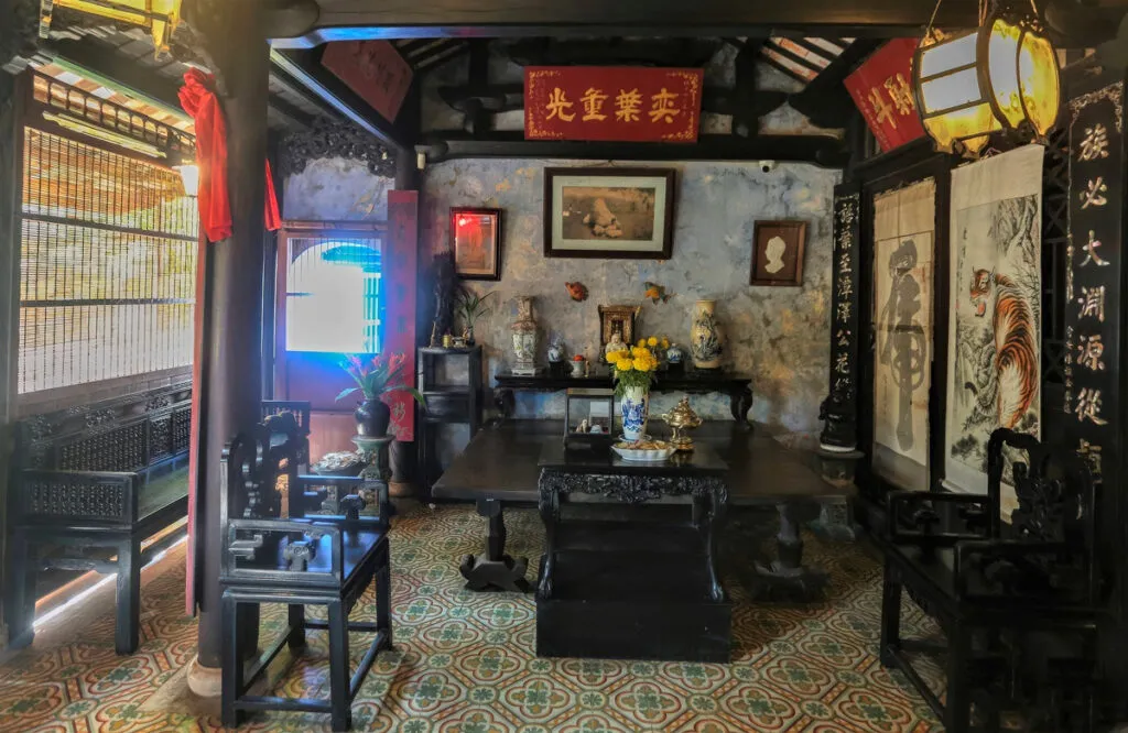 Ornate wooden furniture and vintage floor tiles inside the Tran Family Chapel.